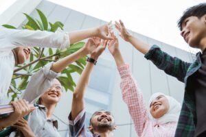 young asian people raising hands as sign unity while together cafe